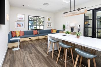 A living room with a couch and a kitchen with a table and chairs